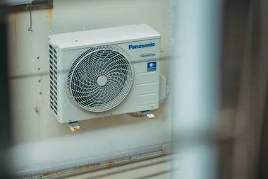 Zewnętrzna jednostka klimatyzatora Panasonic zamontowana na ścianie.