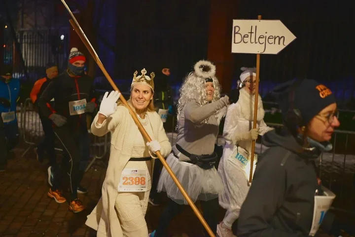 Bieg Trzech Króli w Łodzi - biegacze w kontraście do barwnego orszaku na Piotrkowskiej