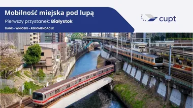 Pociągi metra i kolejki naziemnej przejeżdżają nad rzeką w gęsto zabudowanej dzielnicy tokijskiej, w tle most i wieżowce.